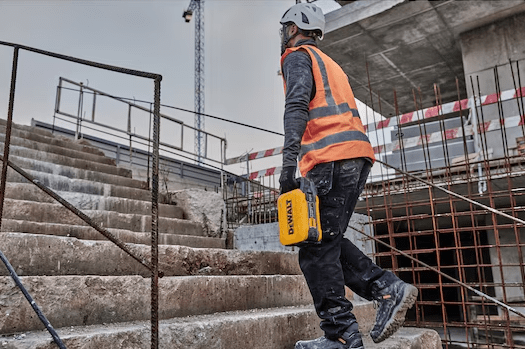 Pracownik niosący akumulator DeWALT